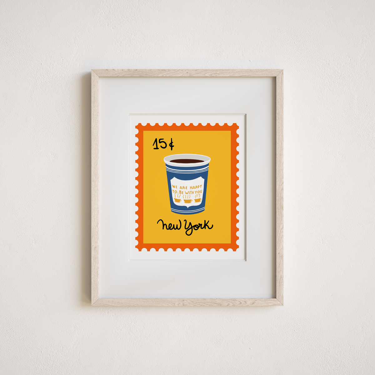 Framed wall art featuring a stylized New York City stamp design with a blue coffee cup on a yellow background, mounted in a light wood frame against a white wall.