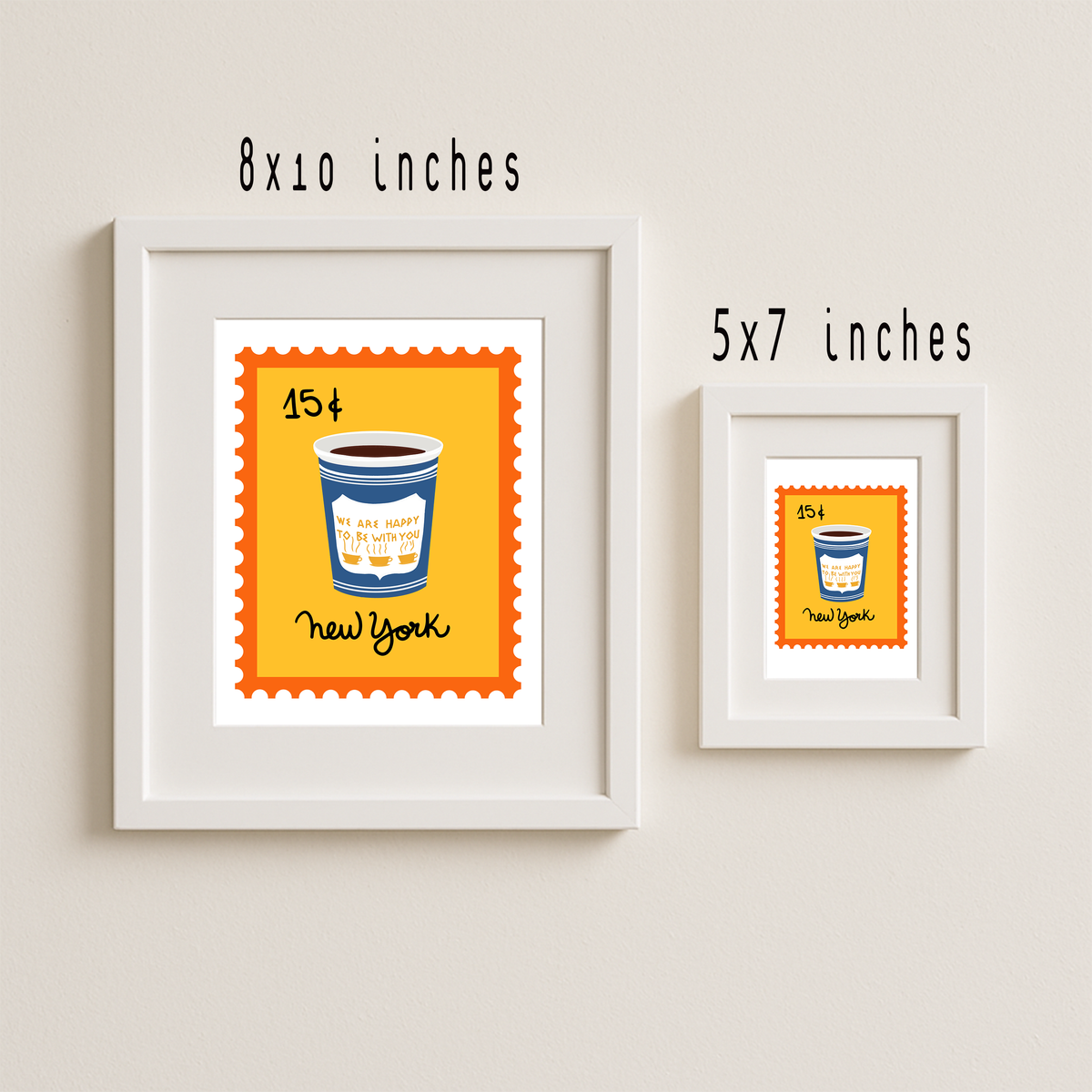 Two framed art prints on a light beige wall, one larger 8x10 inch frame and one smaller 5x7 inch frame. Each print shows a yellow stamp-like design with a blue coffee cup illustration and the words 'New York' and '25¢'.
